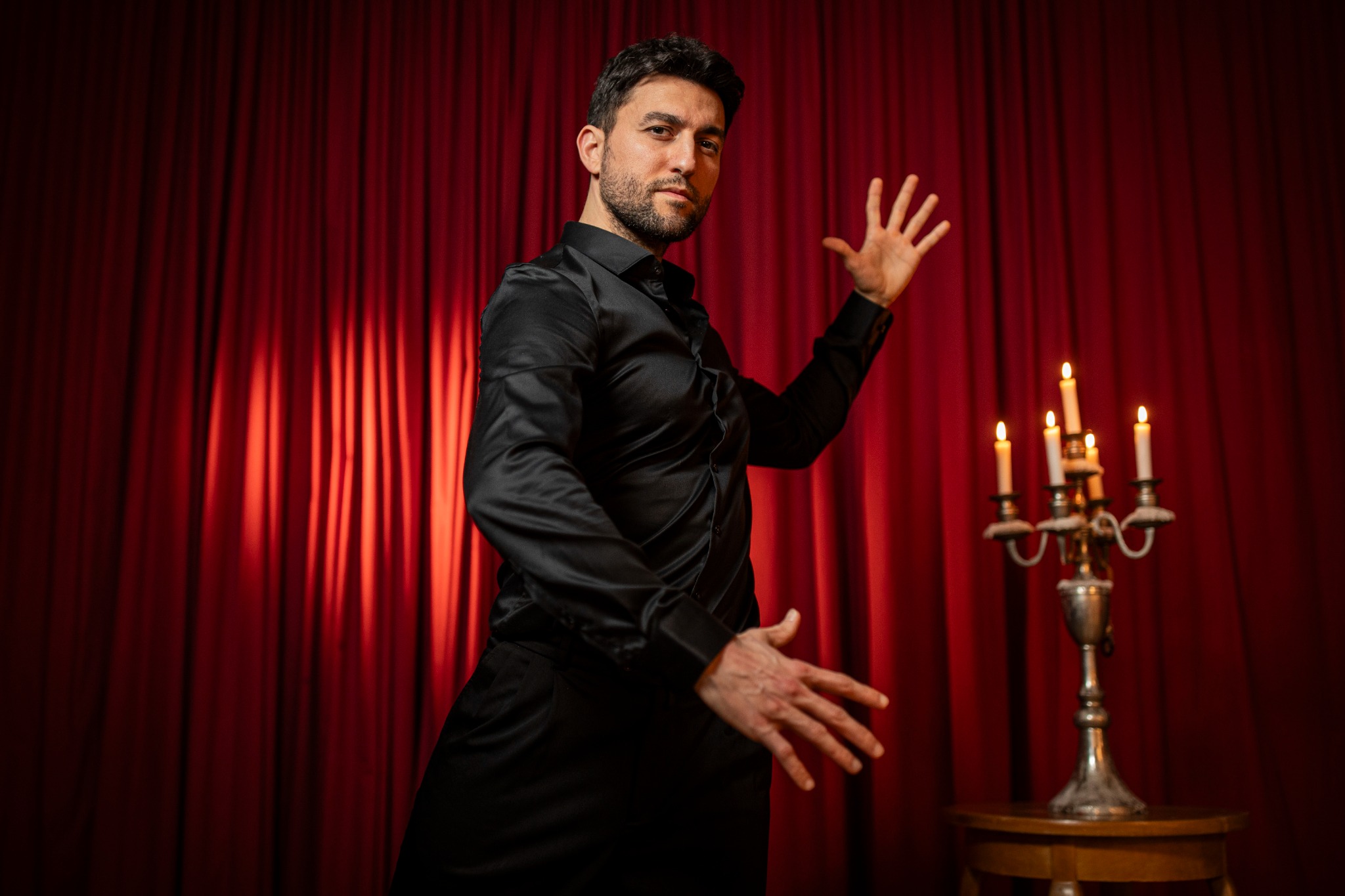 Onur dancing in front of a red curtain